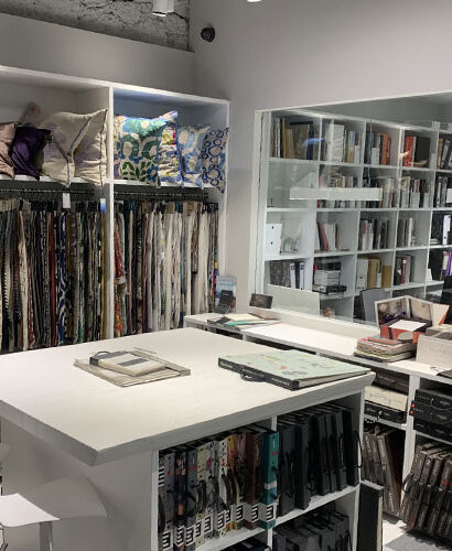 Muestrarios de tejidos, cojines y libros de acabados en el showroom de Interley Interiores.