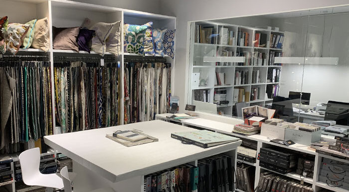 Muestrarios de tejidos, cojines y libros de acabados en el showroom de Interley Interiores.